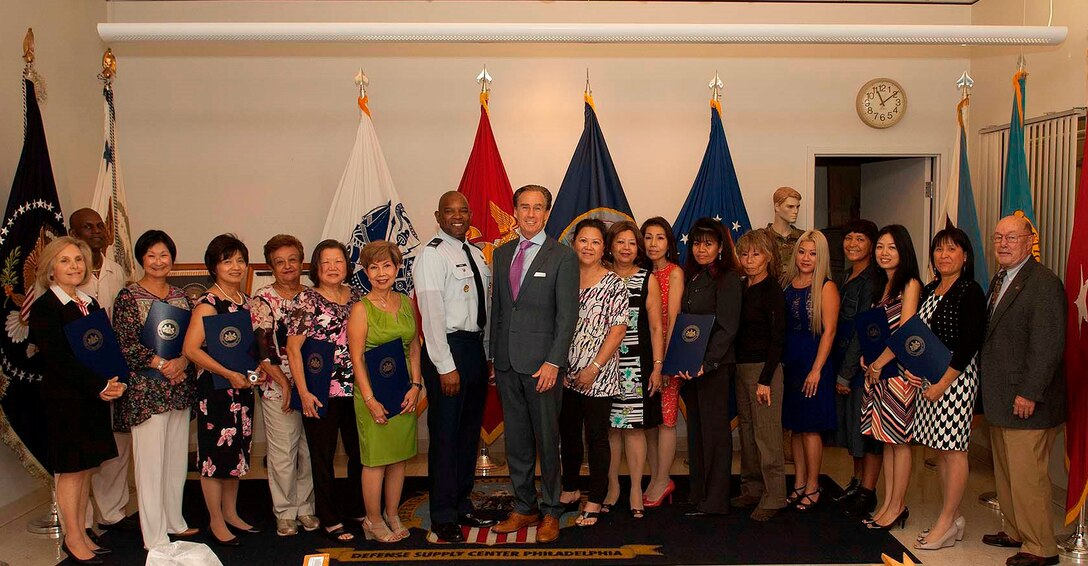 Pennsylvania Lt. Gov. Mike Stack (center right) and DLA Troop Support C&T Director Air Force Col. Lawrence Hicks (center left) pose with flag room employees during a ceremony in their honor Sept. 29 in Philadelphia. Stack presented each employee with a citation and a coin to show his appreciation for the craft and dedication in their work.