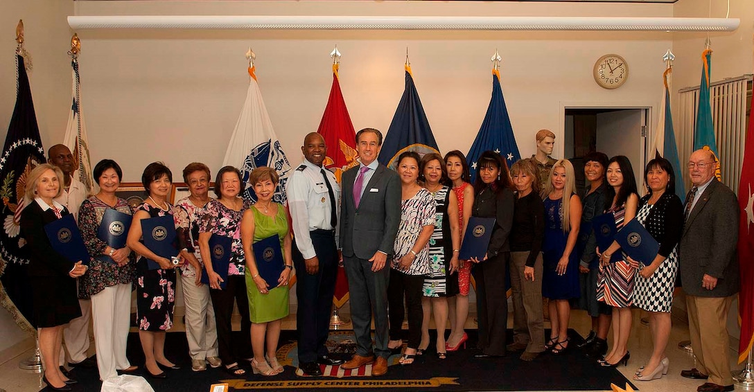 Pennsylvania Lt. Gov. Mike Stack (center right) and DLA Troop Support C&T Director Air Force Col. Lawrence Hicks (center left) pose with flag room employees during a ceremony in their honor Sept. 29 in Philadelphia. Stack presented each employee with a citation and a coin to show his appreciation for the craft and dedication in their work.