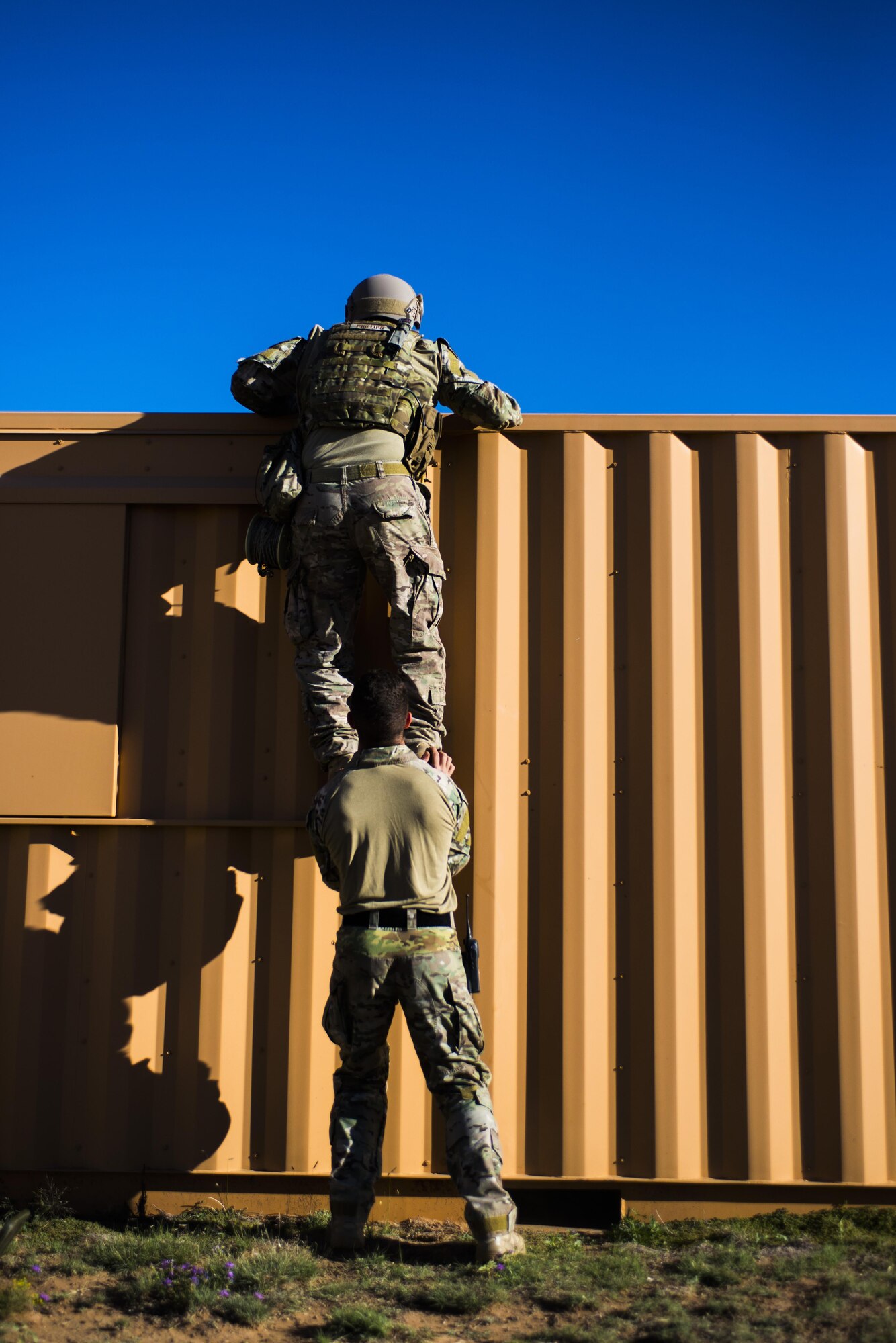Members of the 27th Special Operations Civil Engineer Squadron Explosive Ordnance Disposal flight work together to scale an obstacle during improvised explosive device training at Melrose Air Force Range, N.M., Sept. 28, 2016. EOD members will use different vantage points to view possible areas of threat when deciding possible ways to proceed. (U.S. Air Force photo by Senior Airman Luke Kitterman/Released)