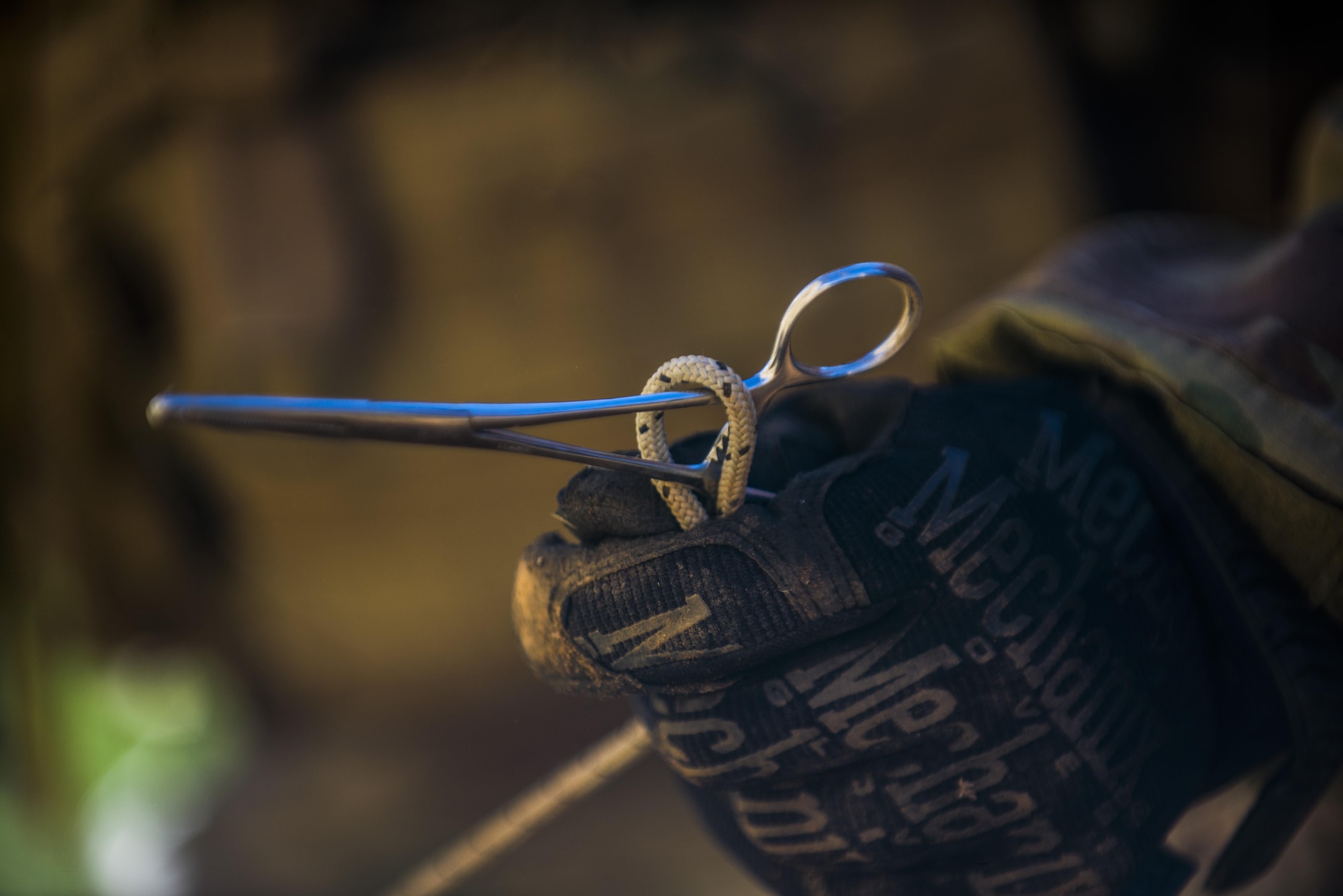 A member of the 27th Special Operations Civil Engineer Squadron Explosive Ordnance Disposal flight holds a pair of forceps during improvised explosive device training at Melrose Air Force Range, N.M., Sept. 28, 2016. The forceps allow the member to clamp down on an object or the attached cord to later pull the object away while at a distance. (U.S. Air Force photo by Senior Airman Luke Kitterman/Released)