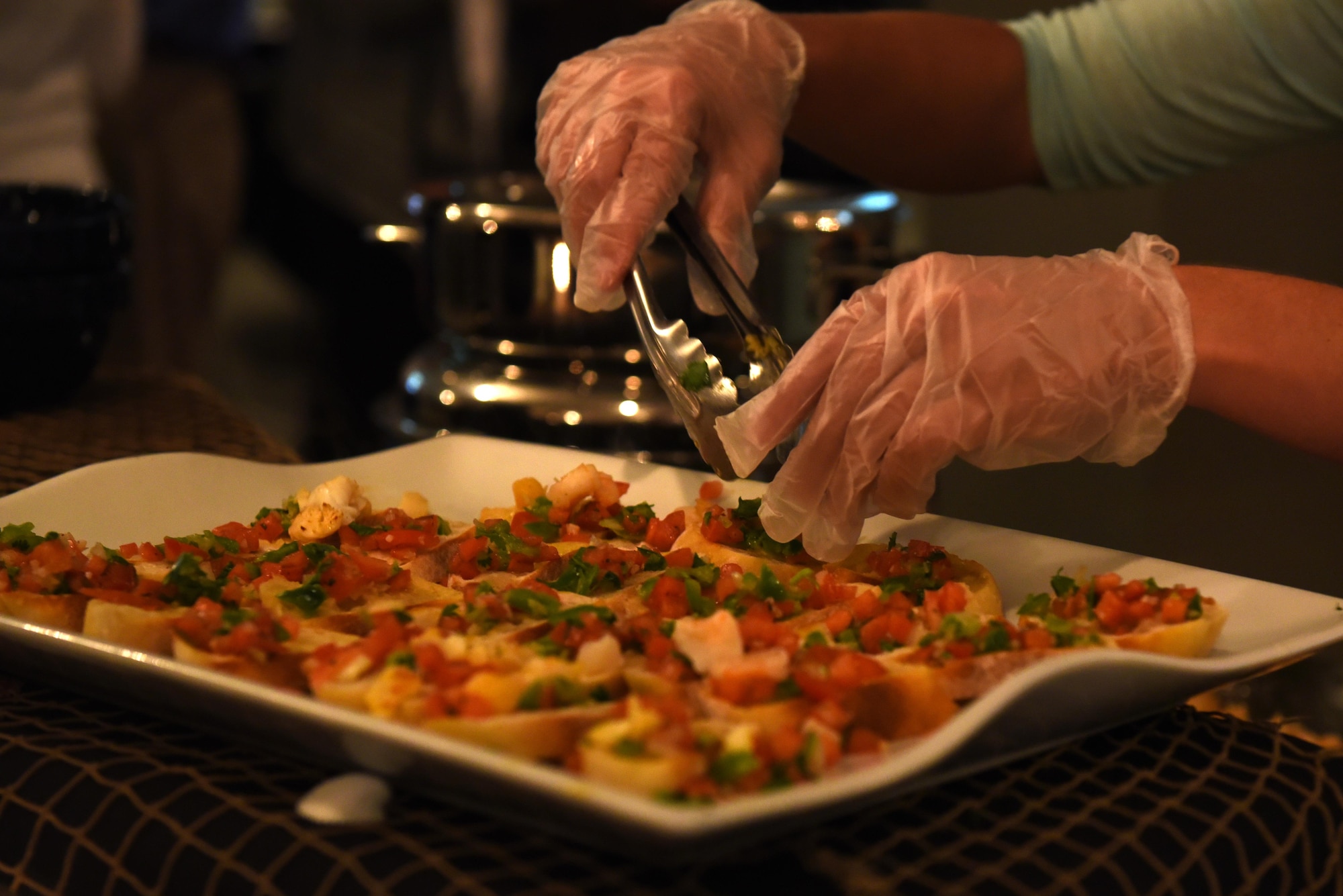 An employee prepares a dish for the food tasting event hosted by the 19th Force Support Squadron Oct. 3, 2016, at Hangar 1080 on Little Rock Air Force Base, Ark. The event provided an opportunity for attendees to sample new food items available at base dining facilities under the 19th FSS non-appropriated funds operation. (U.S. Air Force photo by Airman Kevin Sommer Giron)