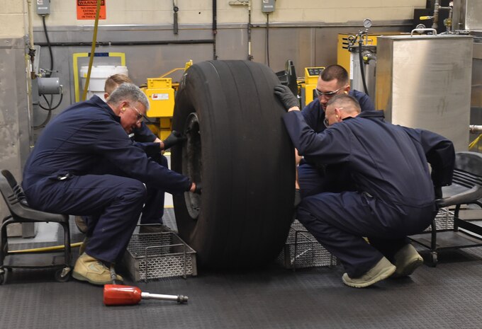 U.S. Air Force Lt. Gen. Sam Cox, 18th Air Force commander, and Chief Master Sgt. Todd Petzel, 18th AF command chief, receive a hands-on lesson on repairing a C-17 tire Sept. 29, 2016, at Joint Base Charleston, South Carolina. Airmen from the 437th Maintenance Squadron ensure that every part of the aircraft is in good working order and safe to use. 