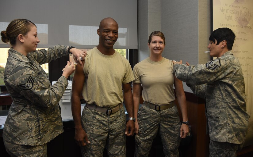Chief Master Sgt. Nathaniel Perry, center left, 779th Medical Group command chief, and Chief Master Sgt. Beth Topa, center right, 11th WG command chief, receive their vaccinations to kick-off the flu shot season at Joint Base Andrews, Md., Oct. 3, 2016. Base leadership received their immunization to kick-off the flu shot drive for retirees, active duty and dependents slated for Oct. 17-18 from 8 a.m. to 4 p.m. at the base theater. The commanders’ shots were given by Staff Sgt. Mallery Niebanck, left, 779th Medical Group allergy and immunization technician, and Master Sgt. Nancy Turner, right, 779th Medical Group immunization backup technician. (U.S. Air Force photo by Airman 1st Class Valentina Lopez)