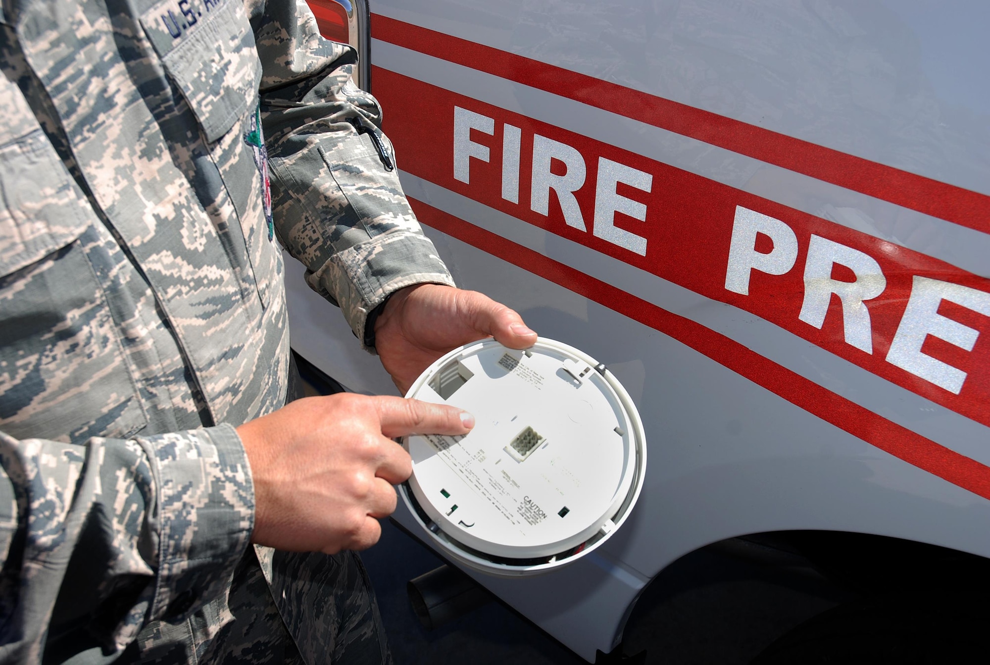 PETERSON AIR FORCE BASE, Colo. – Staff Sgt. Derrick Grinnell, 21st Civil Engineer Squadron Fire Department fire inspector points out where on the unit the manufacturing date can be found on a smoke detector at Peterson Air Force Base, Colo., Sept. 29, 2016. Each detector has a date of manufacture on the base of the unit. (U.S. Air Force photo by Dave Smith)