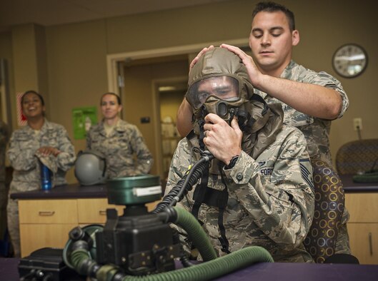 Senior Airman Derrick Eldridge, 433rd Operations Support Squadron aircrew flight attendant technician, secures the aircrew eye respiratory protection system on Master Sgt. Jaron Wagner, 359th Aerospace Medicine Squadron aerospace and operational physiology training flight chief, Sept. 29, 2016 at Joint Base San Antonio-Lackland, Texas. The Airmen received a Survival Evasion Resistance and Escape briefing followed by a tour of a C-5M Super Galaxy aircraft. They were also given an aircrew flight equipment demonstration at the 433rd OSS.  (U.S. Air Force photo by Benjamin Faske)