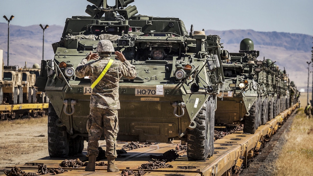 A soldier uses hand signals to guide Stryker armored vehicles at Orchard Combat Training Center, Idaho, Sept. 27, 2016. Army photo by Capt. Brian Harris

