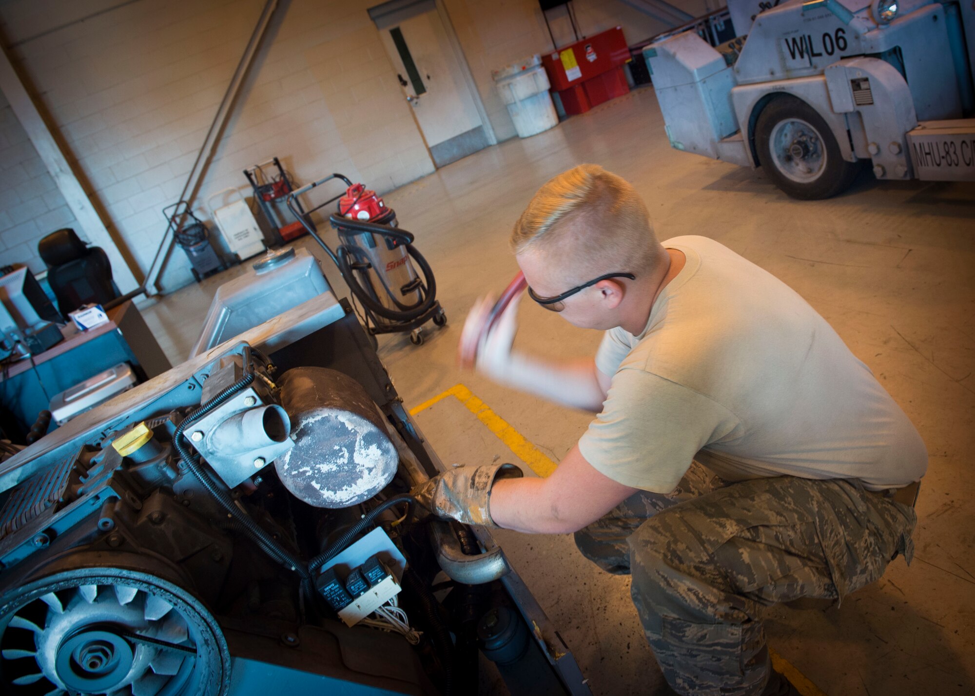 Senior Airman Miles Shepperd, an aerospace ground equipment journeyman with the 1st Special Operations Maintenance Squadron, works to remove an exhaust pipe from a munitions handling unit at the AGE hangar on Hurlburt Field, Fla., Oct. 3, 2016. An MHU is used to assist munitions Airmen with loading ammo onto aircraft. (U.S. Air Force photo by Senior Airman Krystal M. Garrett)