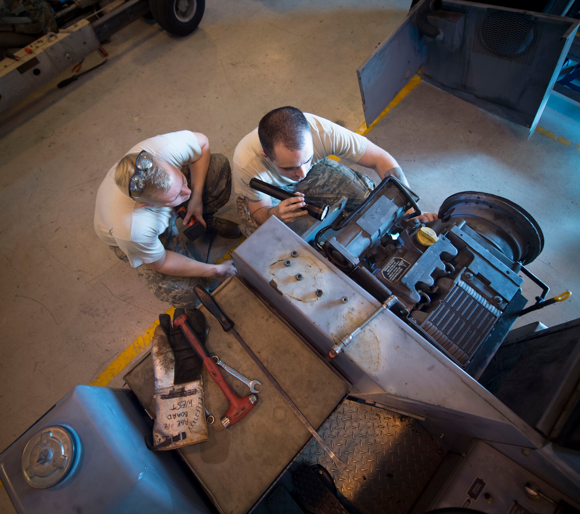 Senior Airman Miles Shepperd, left, an aerospace ground equipment journeyman with the 1st Special Operations Maintenance and Staff Sgt. Robert Pennington, an AGE craftsman, look inside a munitions handling unit at the AGE hangar on Hurlburt Field, Fla., Oct. 3, 2106. An MHU is used to assist munitions Airmen with loading munitions onto aircraft. (U.S. Air Force photo by Senior Airman Krystal M. Garrett)