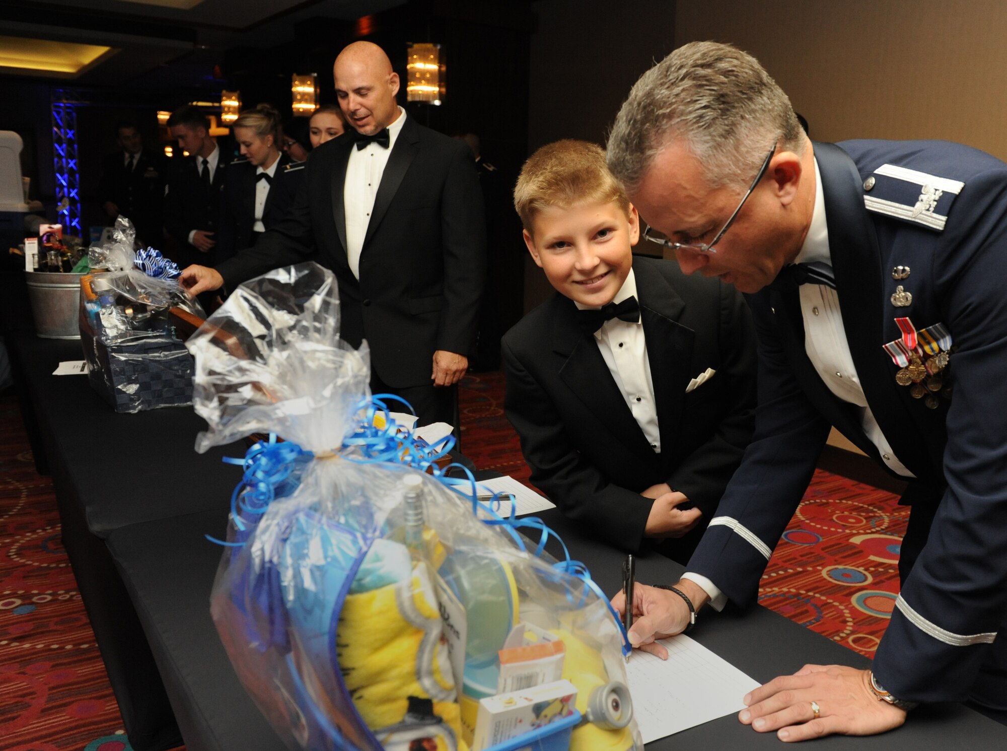 Col. Marty DeStazio, 602nd Training Group (Provisional) commander, participates in the silent auction as his son, Vincent, looks on during the Keesler Air Force Ball at the Imperial Palace Casino Sept. 24, 2016, Biloxi, Miss. The event was sponsored by the Air Force Association John C. Stennis Chapter #332 to celebrate the Air Force’s 69th birthday and the base’s 75th anniversary. (U.S. Air Force photo by Kemberly Groue/Released)