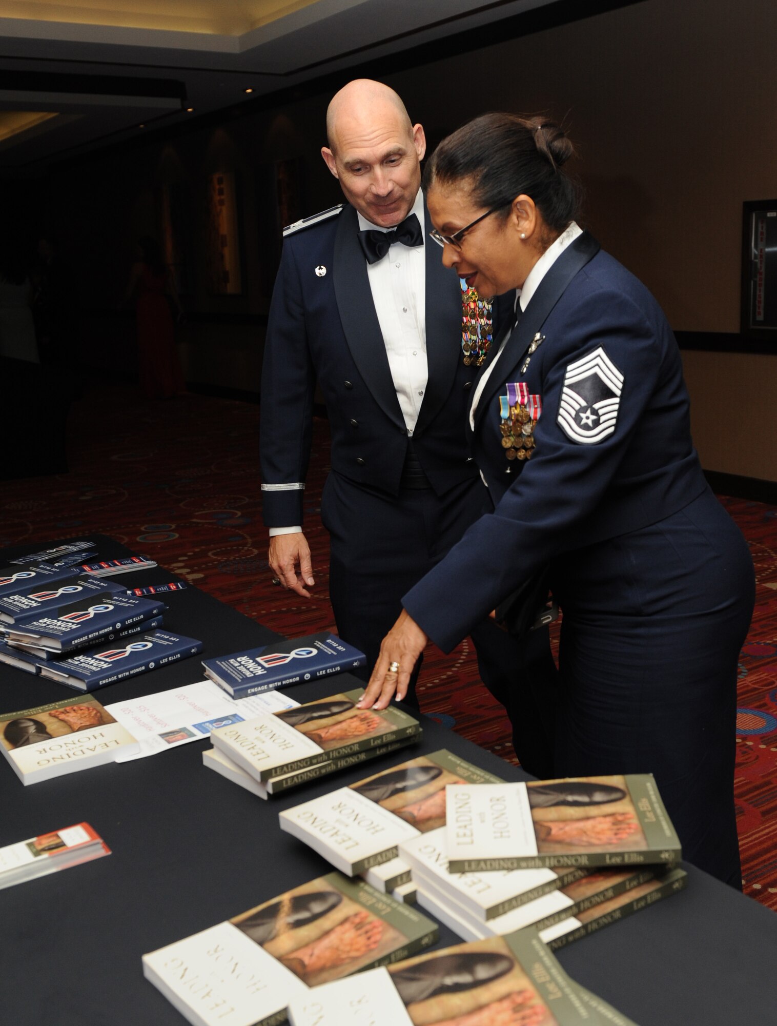 Col. Michael Manion, 403rd Wing commander, and Chief Master Sgt. Jo Keller, 403rd Aeromedical Staging Squadron enlisted manager chief, look at books on display written by the guest speaker, retired Col. Leon Ellis, during the Keesler Air Force Ball at the Imperial Palace Casino Sept. 24, 2016, Biloxi, Miss. The event was sponsored by the Air Force Association John C. Stennis Chapter #332 to celebrate the Air Force’s 69th birthday and the base’s 75th anniversary. (U.S. Air Force photo by Kemberly Groue/Released)