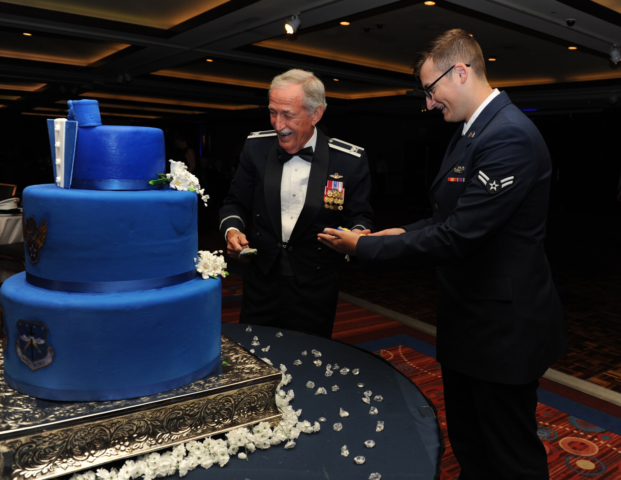 Retired Col. Sid Wright and Airman 1st Class William Henderson, 81st Training Support Squadron network administrator, participate in a cake cutting ceremony during the Keesler Air Force Ball at the Imperial Palace Casino Sept. 24, 2016, Biloxi, Miss. Wright was the oldest Airman at the ball while Henderson was the youngest; it is tradition for the oldest and youngest Airmen in attendance to cut the cake. The event was sponsored by the Air Force Association John C. Stennis Chapter #332 to celebrate the Air Force’s 69th birthday and the base’s 75th anniversary. (U.S. Air Force photo by Kemberly Groue/Released)