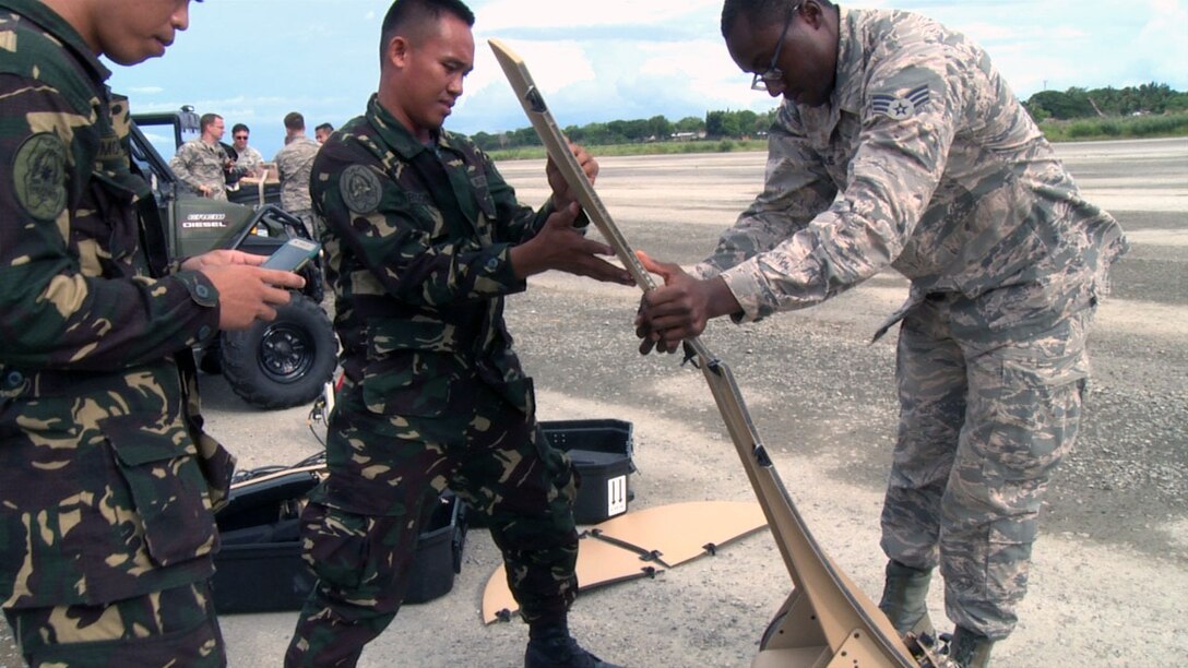 Philippine Air Force Airman 2nd Class Eldie Bryan Obregon and Airman James Monforte, communications professionals, exchange best practices with U.S. Senior Airman Eric Kimble, 18th Expeditionary Airlift Squadron communications specialist, during a subject matter expert exchange regarding a communications flyaway kit during the first day of the current iteration of the Air Contingent at Antonio Bautista Air Base, Philippines, Sept. 26, 2016. The Air Contingent is helping build the capacity of the Philippine Air Force and increases joint training, promotes interoperability and provides greater and more transparent air and maritime situational awareness to ensure safety for military and civilian activities in international waters and airspace. Its missions include air and maritime domain awareness, personnel recovery, combating piracy, and assuring access to the air and maritime domains in accordance with international law. (U.S. Air Force photo by Tech. Sgt. George Maddon)