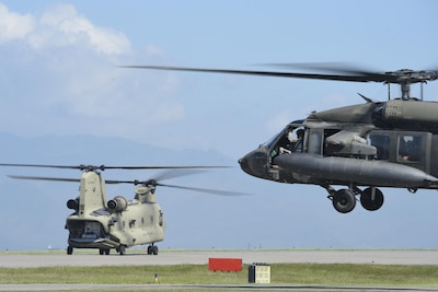A UH-60 Blackhawk and a CH-47 Chinook helicopters assigned to Joint Task Force-Bravo’s 1st Battalion, 228th aviation regiment, prepare to launch from Soto Cano Air Base, Honduras, Oct. 4, 2016, to stage at the Grand Cayman Islands to provide airlift capabilities for Hurricane Matthew relief efforts if requested by the U.S. Agency for International Development’s Office of Foreign Disaster Assistance. The mission of Joint Task Force-Bravo includes being prepared to support disaster relief operations in Central America, South America and the Caribbean, when directed by SOUTHCOM. (U.S. Air Force photo by Staff Sgt. Siuta B. Ika)
