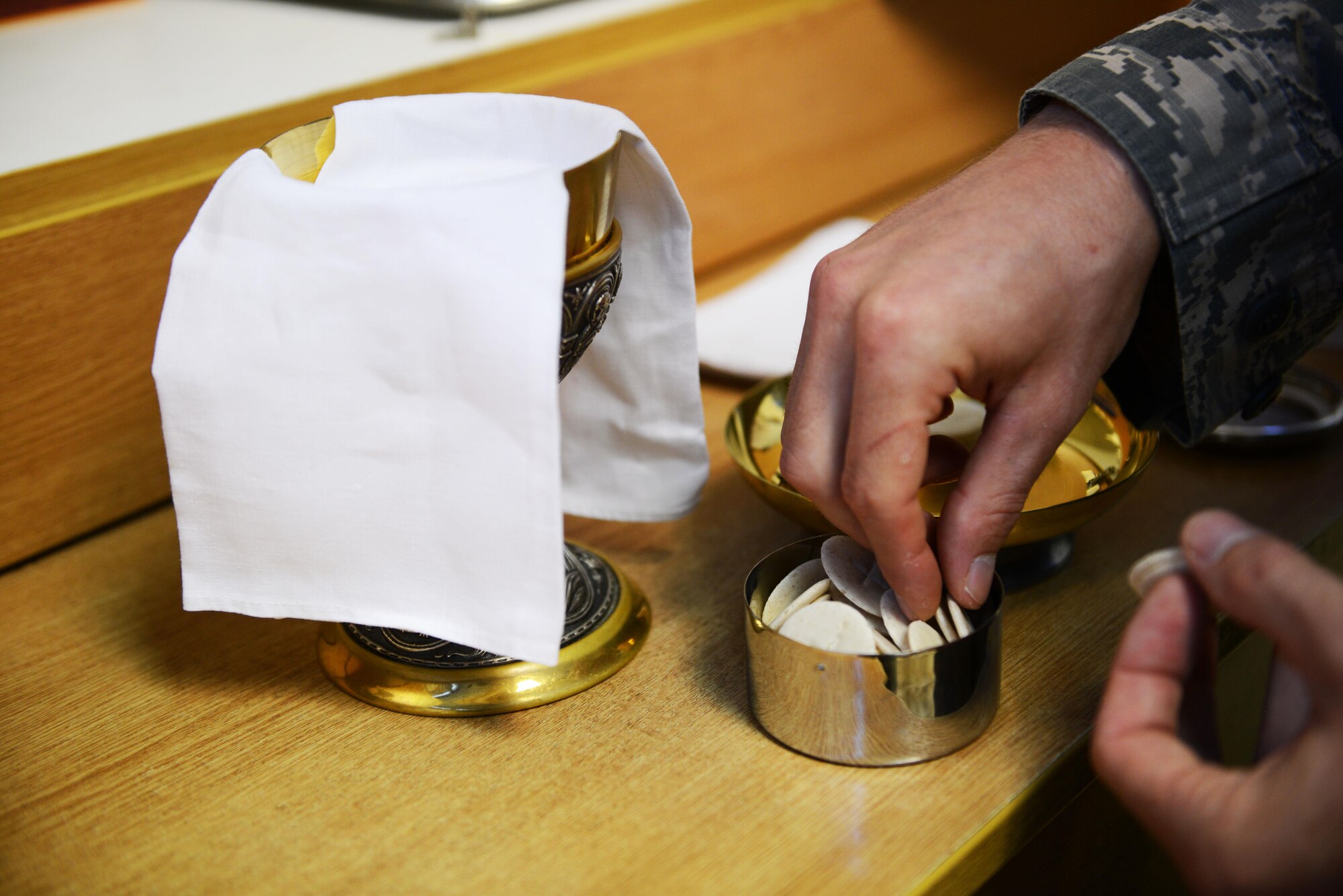 Technical. Sgt. Jere Ross, 86th Airlift Wing chaplain corps NCO in charge of plans and programs, prepares communion elements for a Catholic mass at Ramstein Air Base, Germany, Sept. 21, 2016. Religious support teams, consisting of one chaplain and one chaplain assistant, engage with Airmen using a variety of programs and methods in order to meet their religious and spiritual needs. (U.S. Air Force photo/ Airman 1st Class Joshua Magbanua)