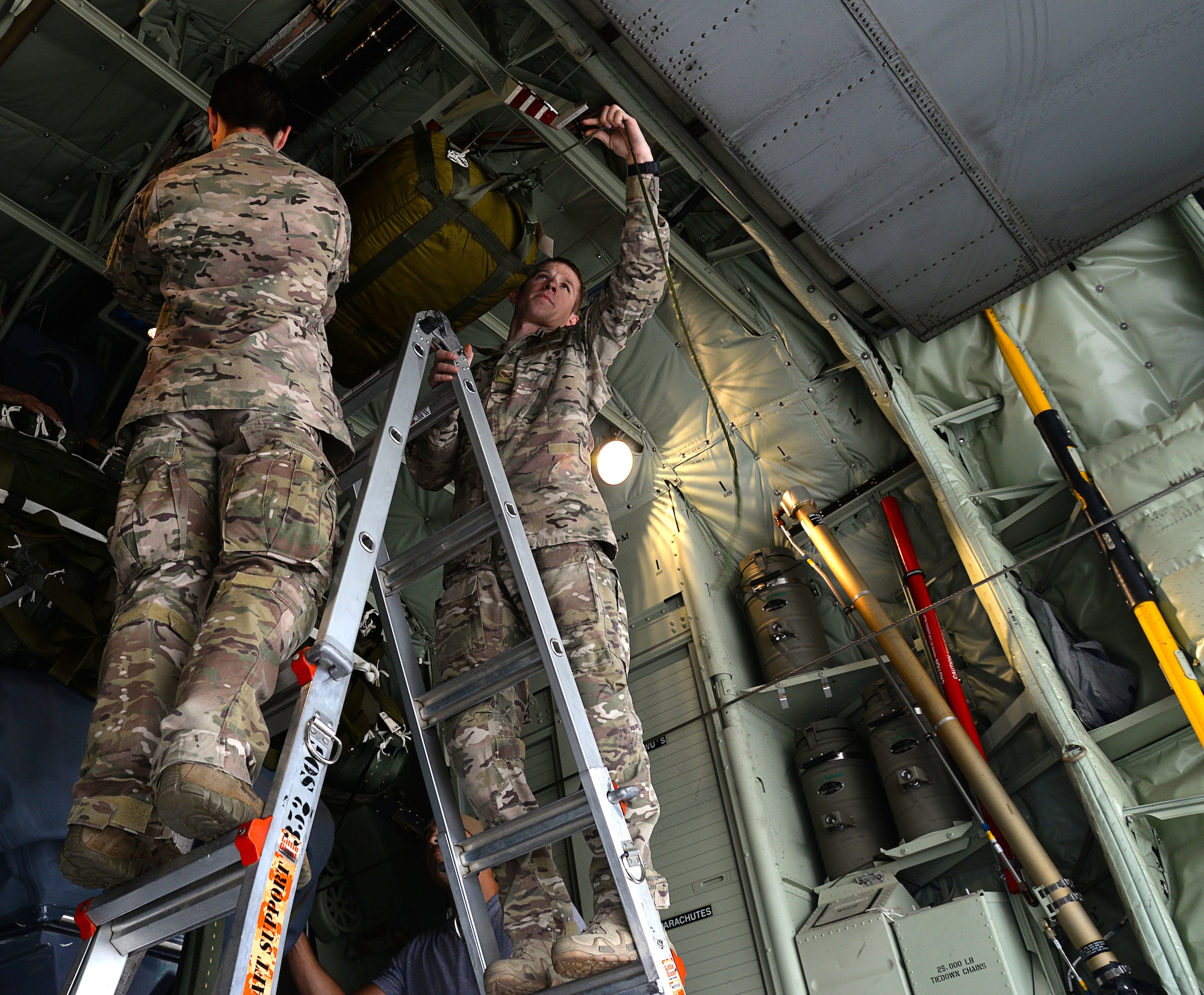 Two U.S. Air Force MC-130J Commando II loadmasters, assigned to the 67th Special Operations Squadron attach a parachute attached to a Rigid Inflatable Boat Sept. 26, 2016, at Stuttgart Air Base, Germany. The aircraft is fitted and inspected in preparation for a Maritime Craft Aerial Delivery drop in participation with the 2016 Night Hawk exercise. (U.S. Air Force photo by Senior Airman Justine Rho)