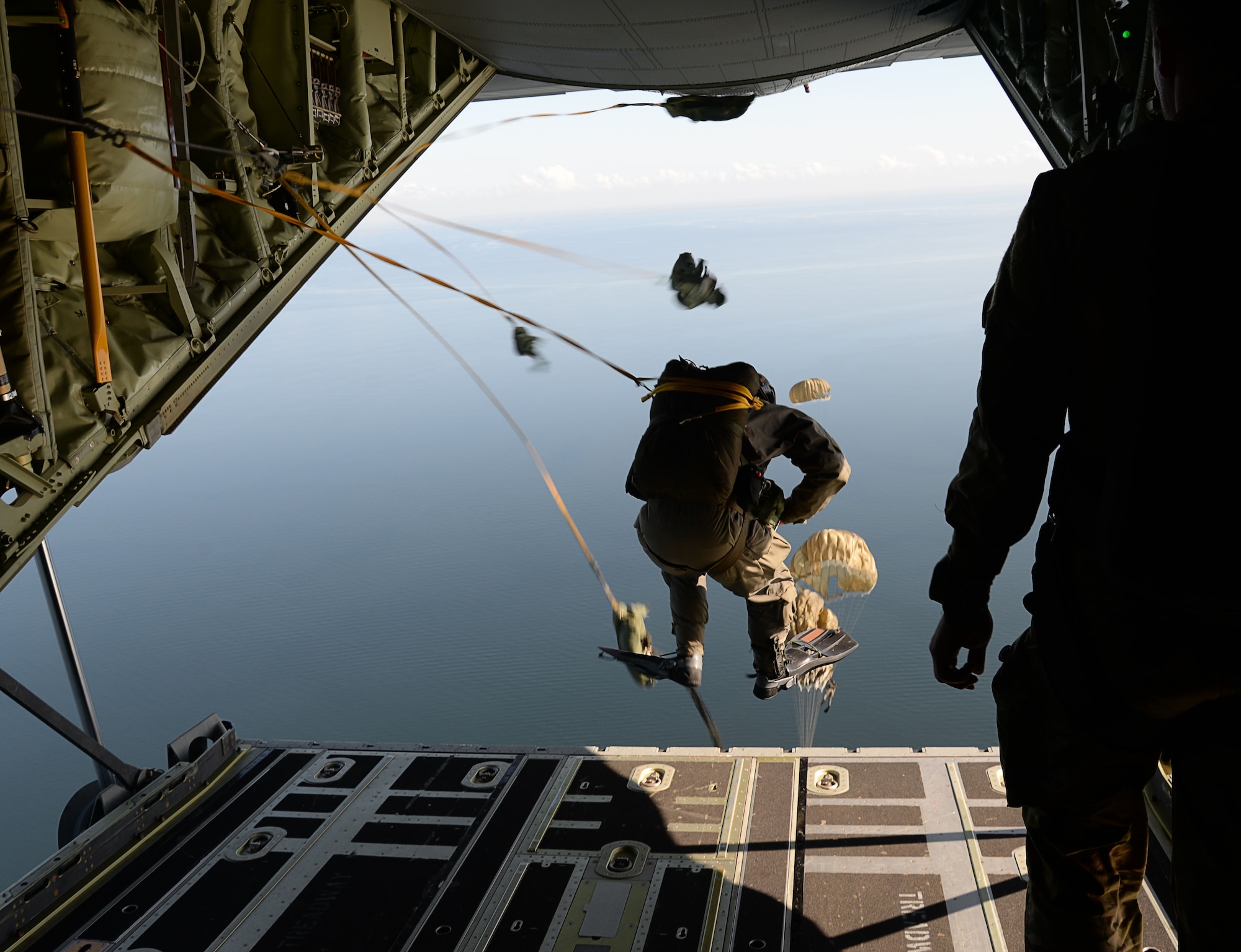 Danish air commandos perform a static-line jump from an U.S. Air Force MC-130J Commando II assigned to the 67th Special Operations Squadron, over the Little Belt Strait in Denmark Sept. 27, 2016. Airmen from RAF Mildenhall, England and U.S. Navy Special Warfare Combatant-Craft crewmen worked with ally forces during the 2016 Night Hawk exercise testing joint force capabilities. (U.S. Air Force photo by Senior Airman Justine Rho)