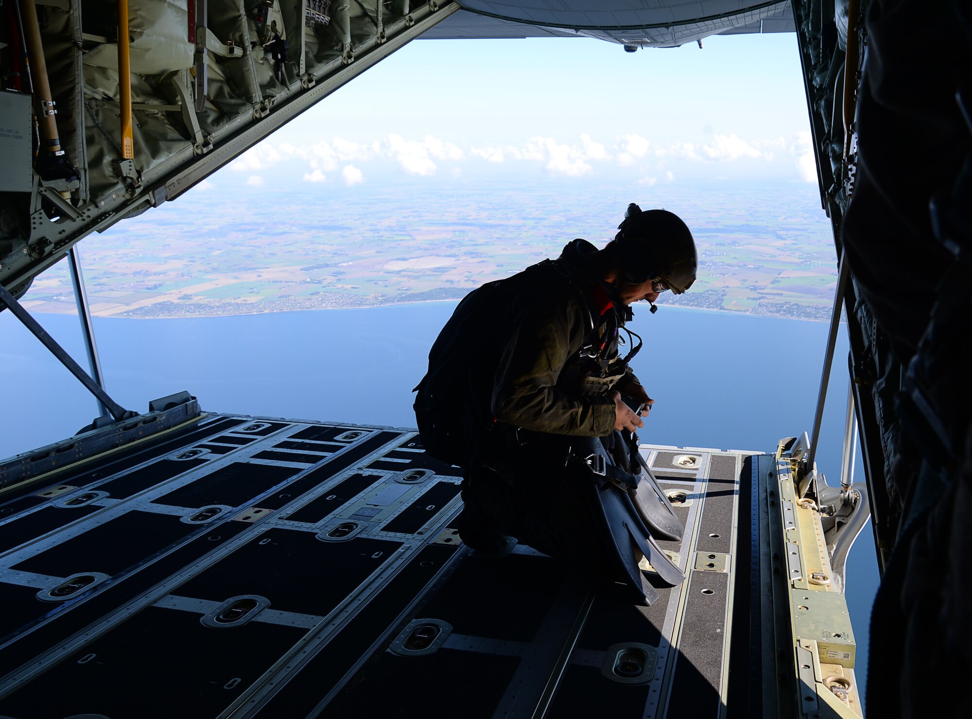 A U.S. Air Force Air Commando assigned to the 352nd Special Operations Wing makes final jump assessments before conducting a free fall from an MC-130J Commando II assigned to the 67th Special Operations Squadron, over the Little Belt Strait in Denmark Sept. 27, 2016. Airmen from RAF Mildenhall, England and U.S. Navy Special Warfare Combatant-Craft crewmen worked with ally forces during the 2016 Night Hawk exercise testing joint force capabilities. (U.S. Air Force photo by Senior Airman Justine Rho) 