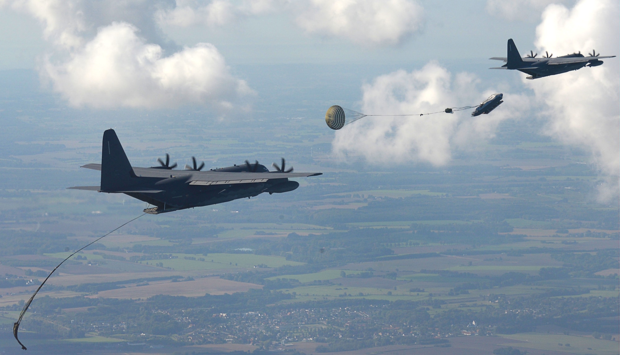 Two U.S. Air Force MC-130J Commando IIs perform Maritime Craft Aerial Delivery System drops over the Little Belt Strait in Denmark Sept. 27, 2016. After the Rigid inflatable Boats were deployed, U.S. Navy Special Warfare Combatant-Craft crewmen followed to set up the equipment. Finally, a third aircraft off loaded U.S. Air Force and Danish air commandos at the drop zone. (U.S. Air Force photo by Senior Airman Justine Rho)