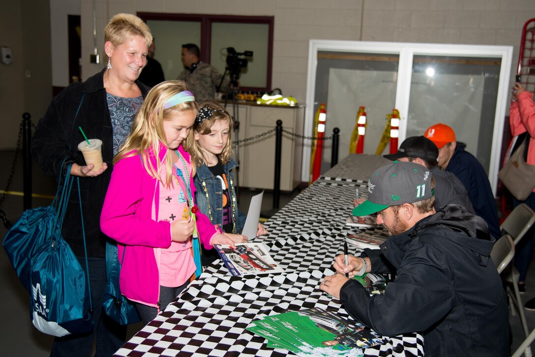 Blake Koch, driver of the No. 11 Leaf Filter Chevy Camaro, signs autographs for Team Dover family members at the NASCAR Social Sept. 30, 2016, at Dover Air Force Base, Del. Several drivers attended the social to sign autographs and take photos with fans. (U.S. Air Force photo by Mauricio Campino)

