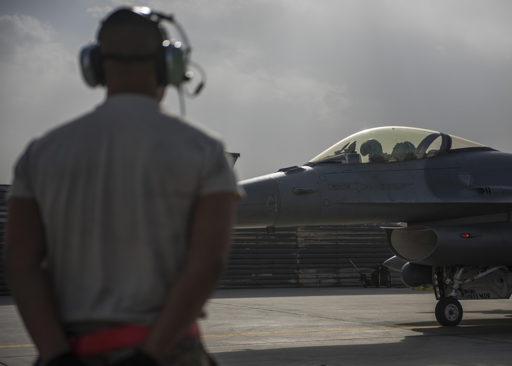 Senior Airman Jean Alonso, 455th Expeditionary Aircraft Maintenance Squadron crew chief, waits to marshal an F-16C Fighting Falcon, Bagram Airfield, Afghanistan, Oct. 5, 2016. Tactical aircraft maintenance technicians otherwise known as crew chiefs are the care takers of the aircraft. They inspect and prepare the aircraft and ensure it is ready to fly at a moment’s notice so pilots can safely and effectively complete their mission. (U.S. Air Force photo by Senior Airman Justyn M. Freeman)