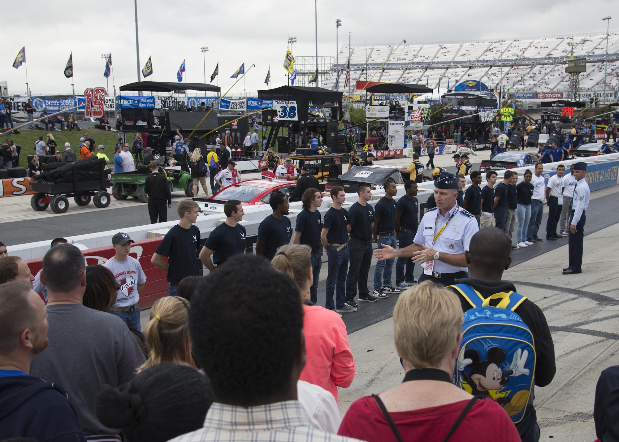 Lt. Gen. Bill Bender, Chief Information Dominance and Chief Information Officer, Office of the Secretary of the Air Force, the Pentagon, Washington, D.C., speaks with family members of military recruits prior to the oath of enlistment Oct. 3, 2016, at Dover International Speedway, Dover, Del. The oath of enlistment took place prior to the Citizen Soldier 400 NASCAR Sprint Cup Series race and had recruits enlisting in the Army and Air Force. (U.S. Air Force photo by Staff Sgt. Jared Duhon)  