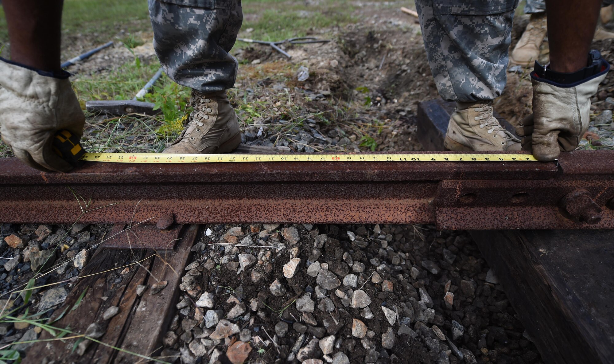 U.S. Army Spc. Mclenzy Bristow, 757th Expeditionary Rail Command railway planning and advisory team member, measures the distance between rail ties during a training course at Joint Base Langley-Eustis, Va., Oct. 4, 2016. Railway planning and advising are part of a new rail field, which was consolidated from three previous railroad specialties in 2015. (U.S. Air Force photo by Staff Sgt. Natasha Stannard) 