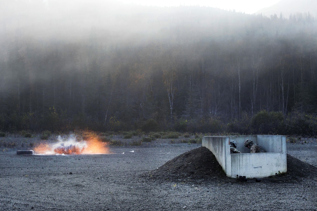 Army 1st Lt. Andres Nanez, left, and Army Sgt. Travis Fort take cover in the safety pit as an M67 fragmentation grenade detonates during a live-fire training exercise on Kraft Range at Joint Base Elmendorf-Richardson, Alaska, Sept. 29, 2016. Nanez and Fort are assigned to the 25th Infantry Division’s Delta Company, 1st Battalion, 501st Parachute Infantry Regiment. Air Force photo by Alejandro Pena