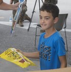 A child takes a handout from the Emergency Awareness Day booth at the commissary on Camp Foster, Okinawa, Sept. 27, 2016. Emergency Awareness Day intends to increase the knowledge of the community by alerting people and providing them with a better understanding of the actions that need to be taken in the case of emergency. (U.S. Marine Corps photo by MCIPAC Combat Camera PFC. Damion Hatch JR/Released)    