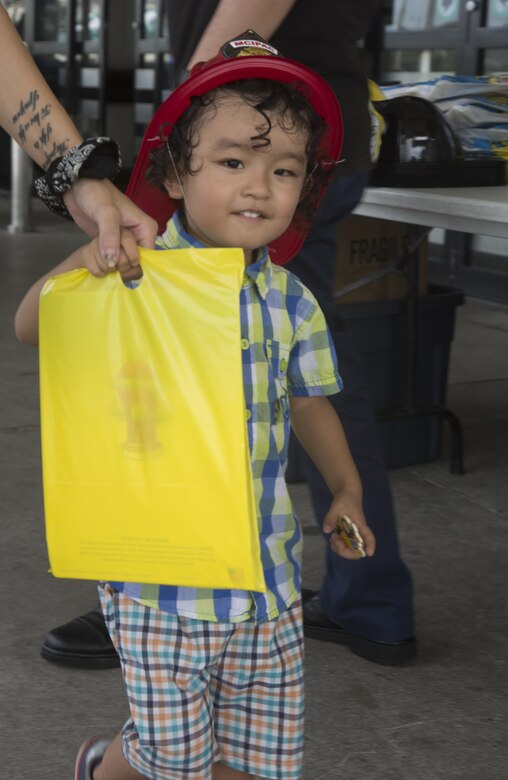 A little boy receives handouts during the Emergency Awareness Day at the commissary on Camp Foster, Okinawa, September 27, 2016. Emergency Awareness Day intends to increase the knowledge of the community by alerting people and providing them with a better understanding of the actions that need to be taken in the case of emergency. (U.S. Marine Corps photo by MCIPAC Combat Camera PFC. Damion Hatch JR/Released)