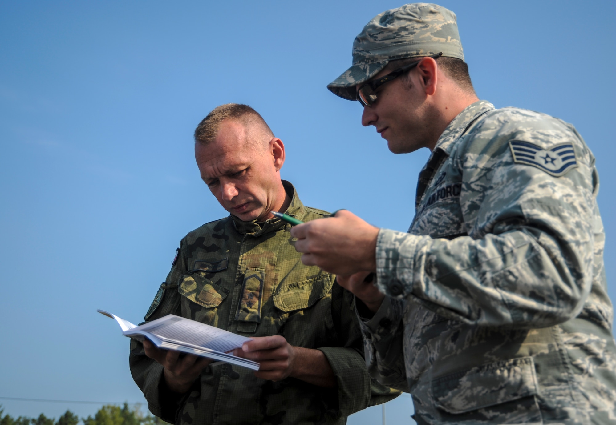 U.S. Air Force Staff Sgt. Joshua Young, 7th Weather Squadron, Detachment 2 weather forecaster, and Polish armed forces Warrant Officer Andrzej Kozlowski, weather forecaster, review a U.S. Army Weather Support Handbook during exercise Cadre Focus 16.2 in Grafenwoehr, Germany, Sept. 27, 2016. Cadre Focus 16.2 is the first time the 7th WS and 7th Expeditionary Weather Squadron invited their Polish and German counterparts to train with them as they refresh skills they need to work with the U.S. Army. (U.S. Air Force photo by Staff Sgt. Timothy Moore)