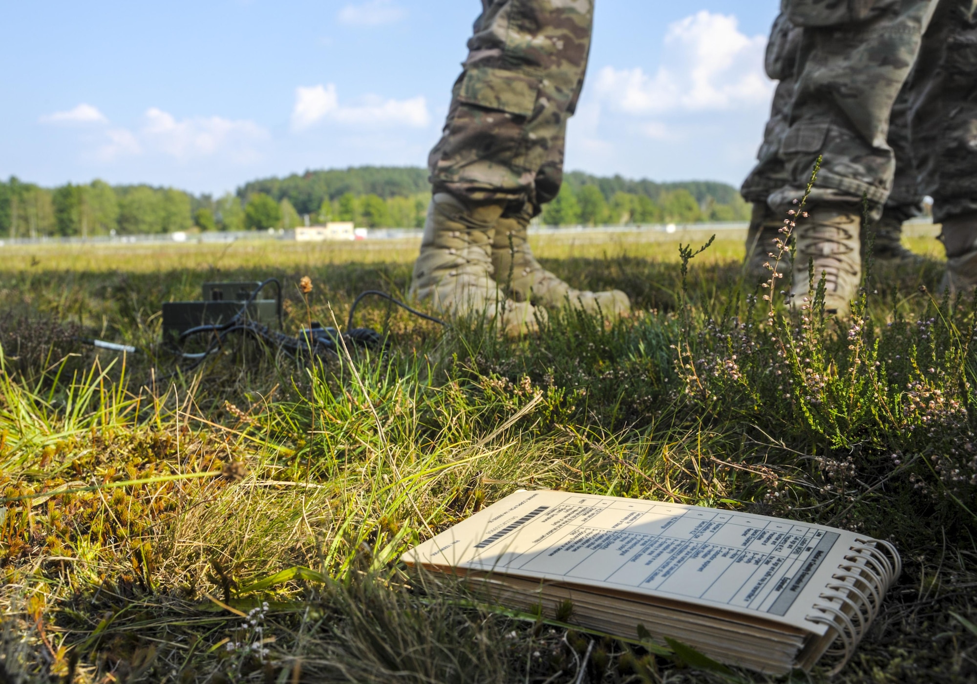 A handbook turned to the 9-line medevac form lies in the grass near a pickup zone during an exercise Cadre Focus 16.2 training scenario in Grafenwoehr, Germany, Sept. 27, 2016. U.S. armed forces members use the 9-line medevac form to quickly transmit information and request a medical evacuation. The request can be used in both peace and wartime scenarios. (U.S. Air Force photo by Staff Sgt. Timothy Moore)