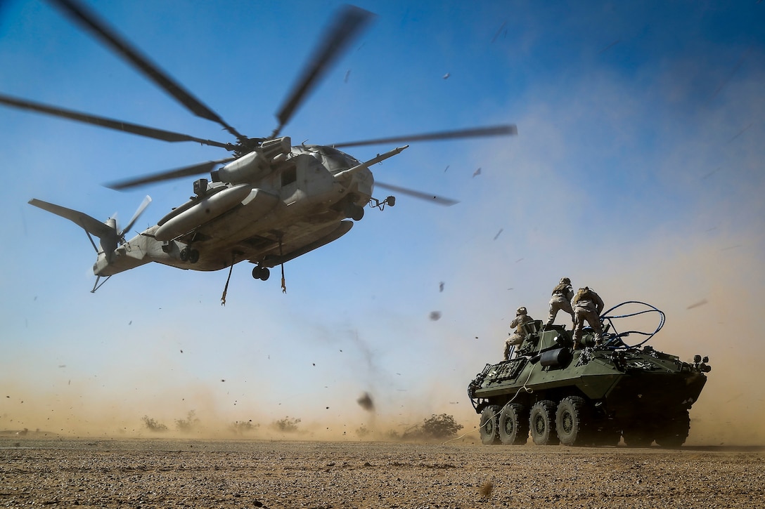 A Marine Corps CH-53E Super Stallion helicopter and Marines prepare to lift a light armored vehicle during a slingload tactics exercise at Auxiliary Airfield II, Yuma, Ariz., Sept. 30, 2016. Marine Corps photo by Staff Sgt. Artur Shvartsberg