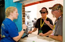 First Lt. Taylor Stephens, 3d Airlift Squadron pilot, takes a food order from a customer during the Citizen Soldier 400 NASCAR Sprint Cup Series race Oct. 2, 2016, at Dover International Speedway, Dover, Del. Stephens and other members of the 3d AS volunteered to work the concession stand to raise money for the squadron booster club. (U.S. Air Force photo by Roland Balik)
