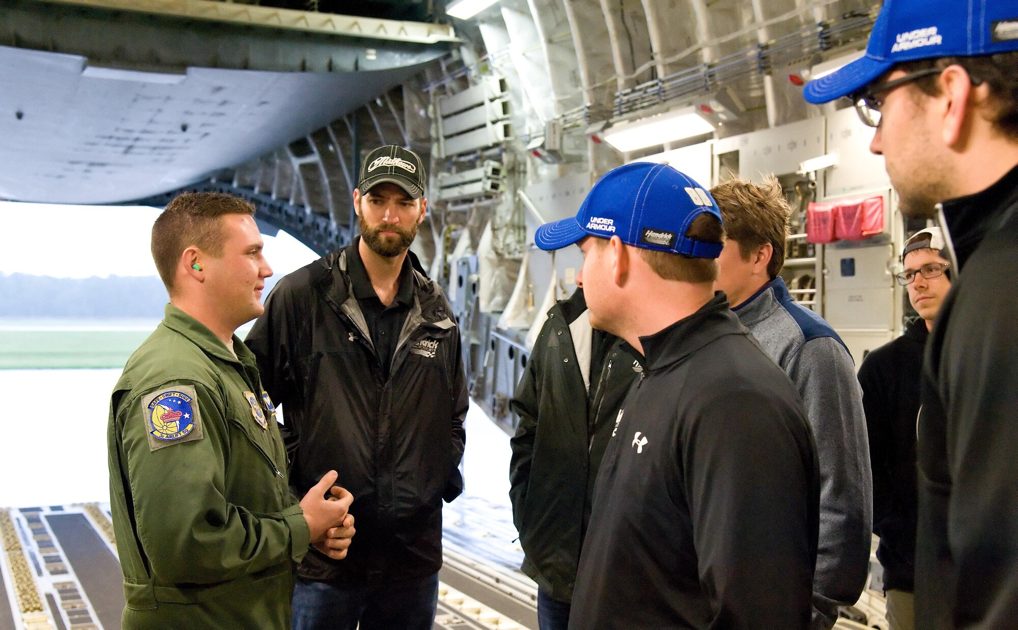 Airman Taylor Trapp, 3d Airlift Squadron loadmaster, answers questions from NASCAR team members about the C-17A Globemaster III Sept. 29, 2016, on Dover Air Force Base, Del. Trapp was a member of a 3d AS aircrew that took more than 40 participants on a NASCAR orientation flight. (U.S. Air Force photo by Roland Balik)