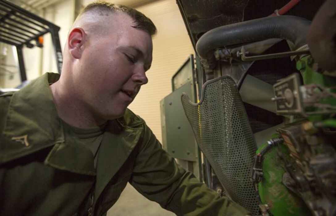 Lance Cpl. Gus O’Brien, an engineer equipment electrical systems technician, Combat Logistics Company 11, Combat Logistics Regiment 15, looks over his work before continuing repairs on a generator aboard Marine Corps Air Station Miramar, Calif., July 22. Microgrids allow generators like these to ensure higher power quality and smooth the output of renewable energy sources, which provides backup power for the entire system, all while lowering costs. (U.S. Marine Corps photo by Cpl. Christopher Johns)