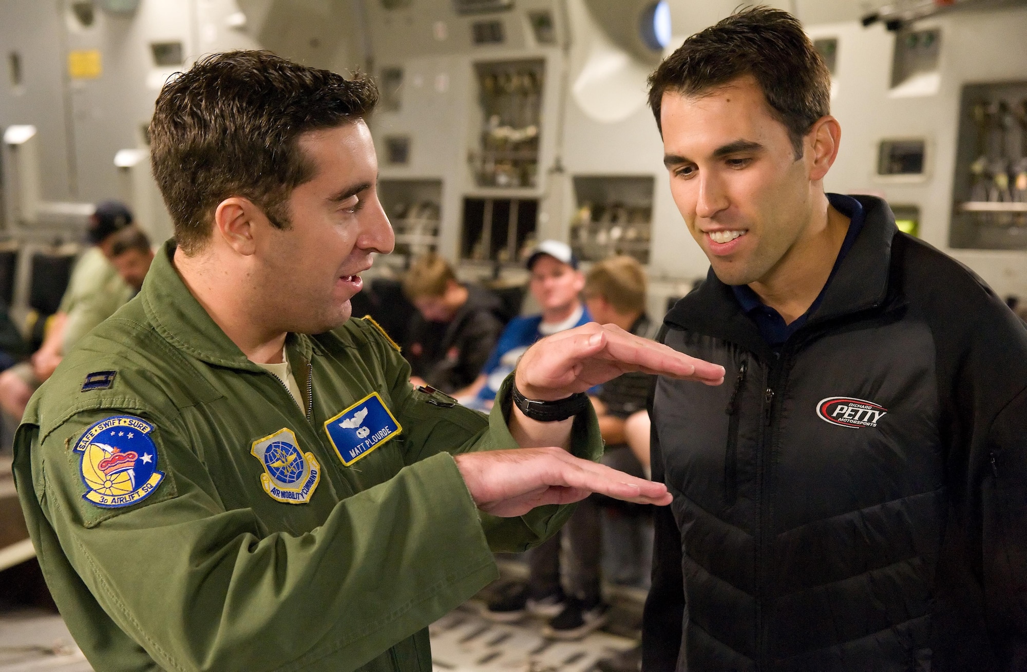 Capt. Matt Plourde, 3d Airlift Squadron pilot, left, explains to Aric Almirola, NASCAR Sprint Cup Series driver for the No. 43 Smithfield Ford, how the C-17A Globemaster III will position itself for air refueling Sept. 29, 2016, on Dover Air Force Base, Del. During the orientation flight, Almirola watched the Globemaster III being refueled by a KC-135R Stratotanker from the 459th Air Refueling Wing, Joint Base Andrews, Md. (U.S. Air Force photo by Roland Balik)