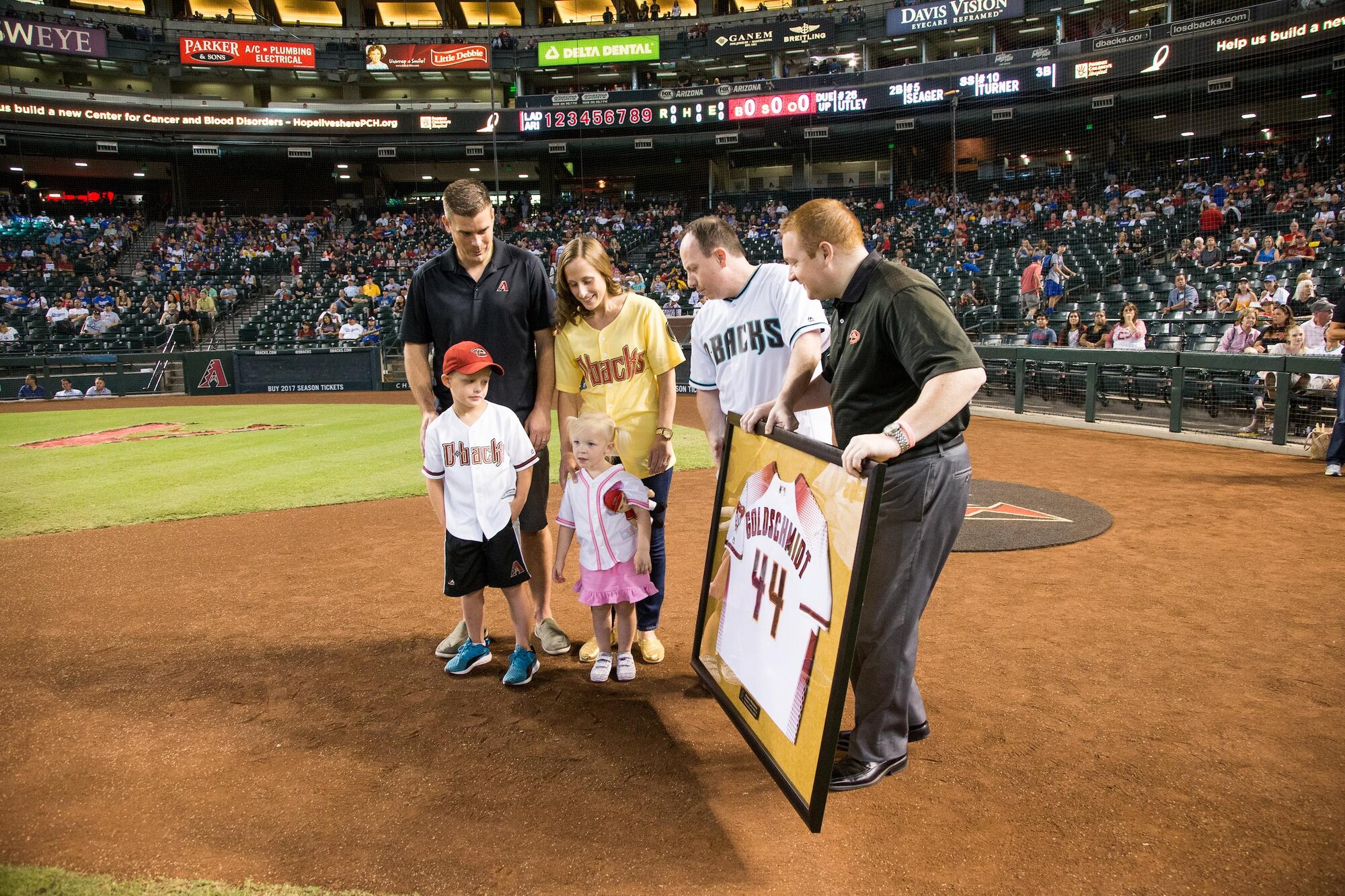 Mason Weedman, son of Carrie and Maj. Aaron Weedman, 69th Fighter Squadron instructor pilot, and cancer survivor and his family are honored at a Arizona Diamondback game Sep. 18 and presented a framed jersey from the organization courtesy of Sprint at Chase Field, Phoenix, Ariz. (Photo by Sarah Sachs/Arizona Diamondbacks)