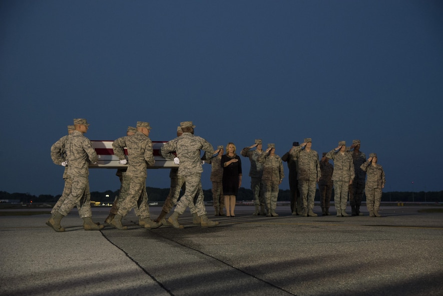 An Air Force carry team carries the remains of Maj. Troy Gilbert as the official party renders honors during a dignified transfer Oct. 3, 2016, at Dover Air Force Base, Del. Maj. Troy Gilbert, an F-16 Fighting Falcon pilot, was killed Nov. 27, 2006, in an F-16 crash 30 miles southwest of Balad Air Base, Iraq. Gilbert was the standardization and evaluation chief for the 332nd Expeditionary Operations Group and was deployed from the 309th Fighter Squadron from Luke Air Force Base, Ariz. (U.S. Air Force Photo by Senior Airman Aaron J. Jenne)