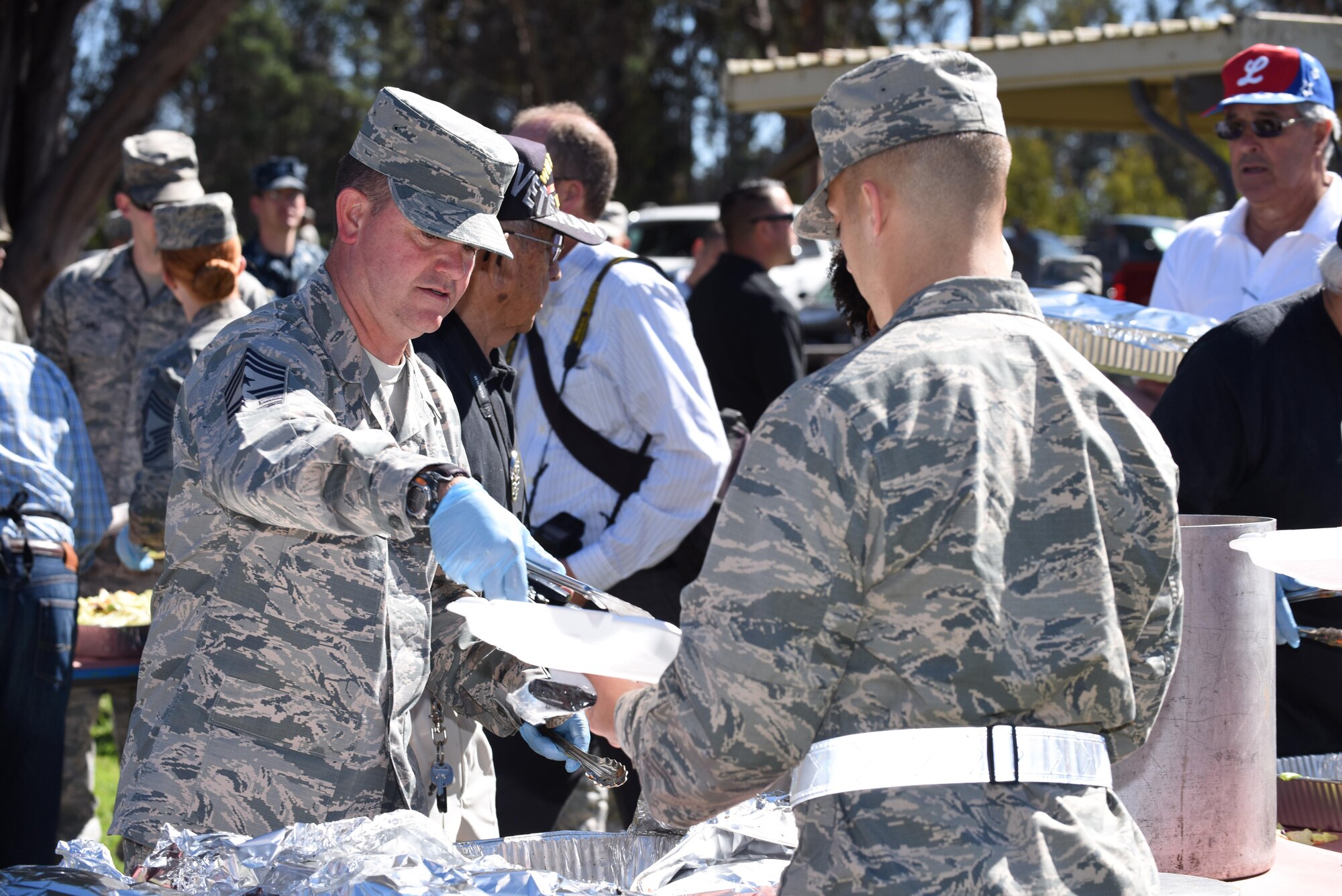 Chief Master Sgt. Robert Bedell, 30th Space Wing command chief, serves an Airman food during a military appreciation barbeque, Oct. 4, 2016, Vandenberg Air Force Base, Calif. More than 1,100 Team V personnel were served meals during the event, which was organized by the Military Affairs Committee of Lompoc. 