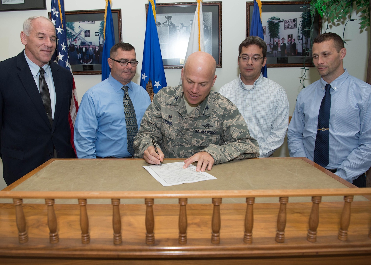 Col. Roman L. Hund, installation commander, signs an Energy Action Month proclamation in Building 1305 Sept. 30, while Thomas Schluckebier, left-to-right, Mike Lynch, David Wong and Brett Castle look on. As part of the month-long campaign, the 66th Civil Engineering Division requests employees find ways to reduce energy and water consumption at work, home and in their communities. (U.S. Air Force photo by Jerry Saslav)