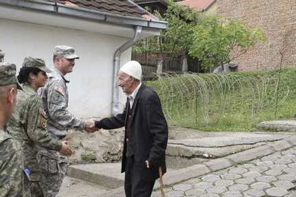 Sgt. 1st Class Obadiah Meyers (middle), Iowa National Guard (IANG) soldier from the 67th Troop Command, shakes hands with a resident of Prizren, Kosovo (right) while on a tour of the city during the IANG staff ride on Monday, September 12, 2016. Staff Sgt. Valbona Kerolli (left), nurse with the Kosovo Security Force (KSF) Medical Company, prepares to shake hands with the gentleman next. Iowa and the Republic of Kosovo have partnered through the National Guard Bureau State Partnership Program since 2011. 