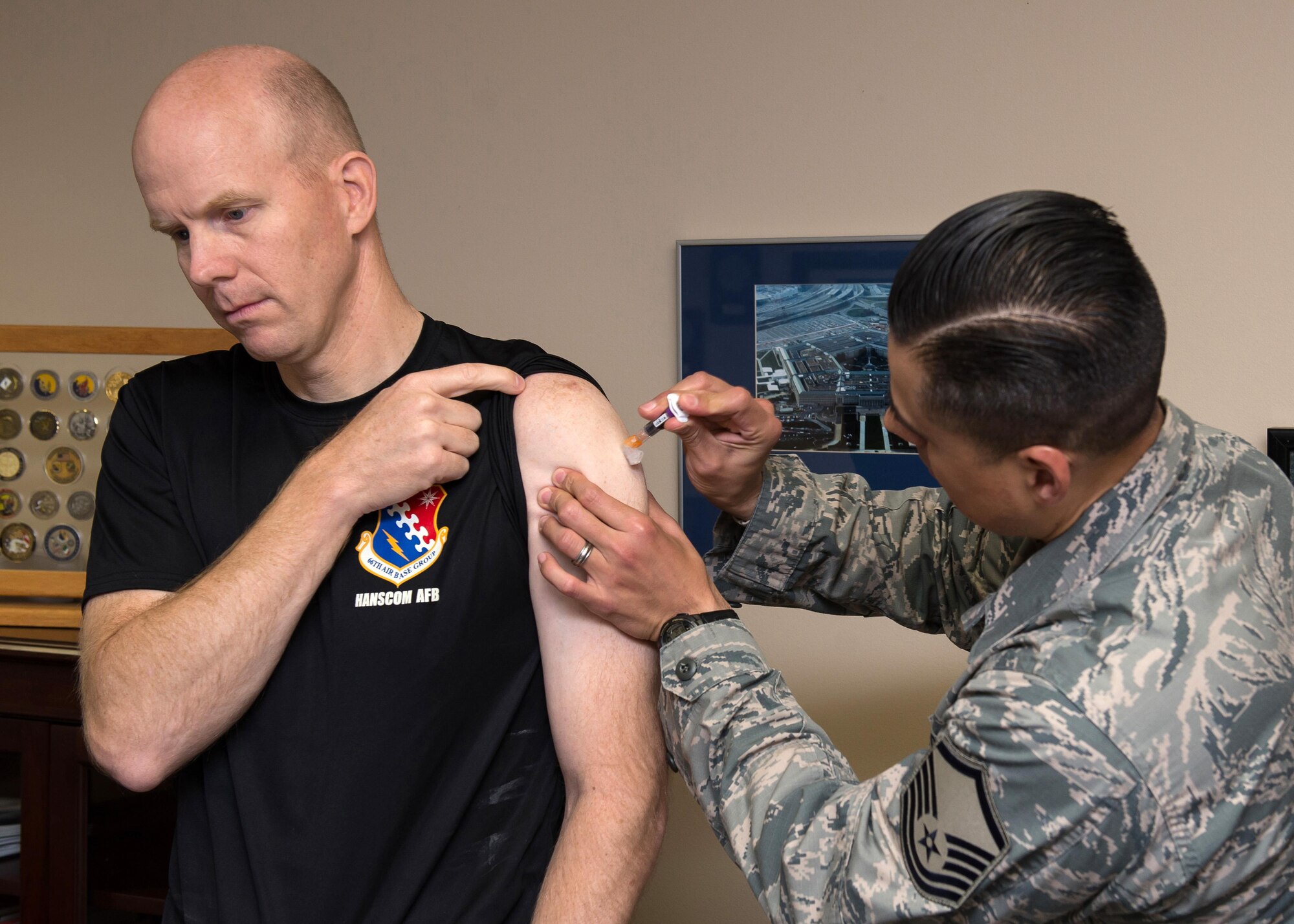 Lt. Col. Kenneth A. Ferland, 66th Air Base Group deputy commander, receives a flu shot from Master Sgt. Eddie Escamilla, Jr., a member of the 66th Medical Squadron, on base Sept. 30. The clinic has received a limited supply of vaccinations only offered to deployers, first responders and active duty units at Hanscom at this time. Public Health will notify the community when more shipments are received (U.S. Air Force photo by Mark Wyatt) 
