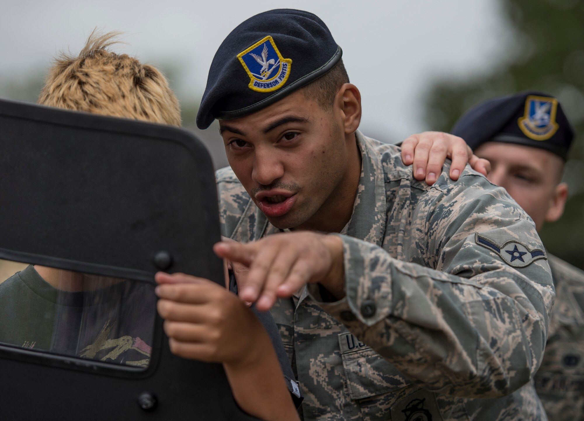 Airman Emmanuel Enos, 375th Security forces Squadron, shows a middle school student how he to stack in riot situations on Scott Air Force Base, Ill., Sept. 29, 2016.  