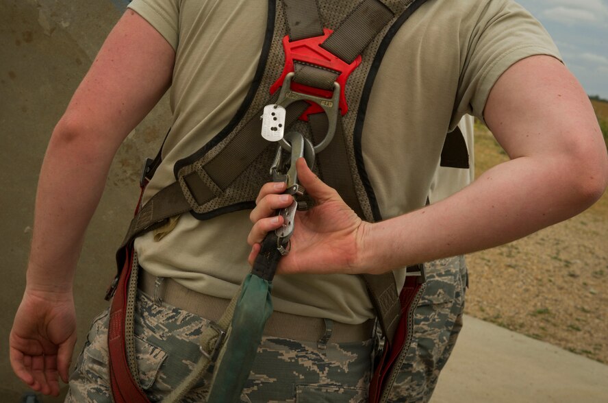 Senior Airman Ian Steck, 91st Missile Maintenance Squadron periodic maintenance team technician, adjusts his harness at the A-09 launch facility in the missile complex, N.D., Sept. 7, 2016. PMT Airmen are harnessed in while lowering equipment down to the launcher equipment room. (U.S. Air Force photo/Senior Airman Apryl Hall)