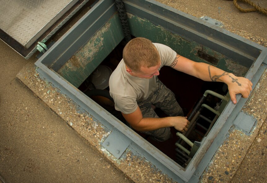 Airman 1st Class Cody Burgher, 91st Missile Maintenance Squadron periodic maintenance team technician, emerges from the launch support building at the A-09 launch facility in the missile complex, N.D., Sept. 7, 2016. In the LSB, PMT Airmen maintain diesel engines, air conditioning units and other equipment necessary for launch facilities to function properly. (U.S. Air Force photo/Senior Airman Apryl Hall)