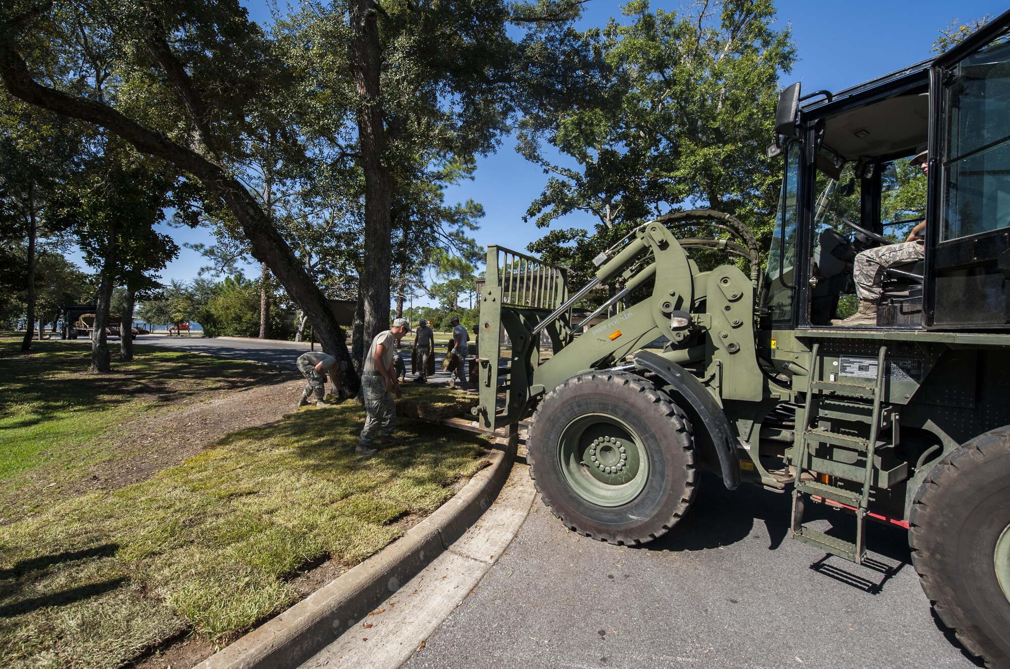 Airmen with the 1st Special Operations Civil Engineer Squadron lay sod at Hurlburt Field, Fla., Oct. 4, 2016. Civil engineer Airmen laid 34 pallets of sod outside the Soundside Club to replace dead grass. (U.S. Air Force photo by Airman 1st Class Joseph Pick)
