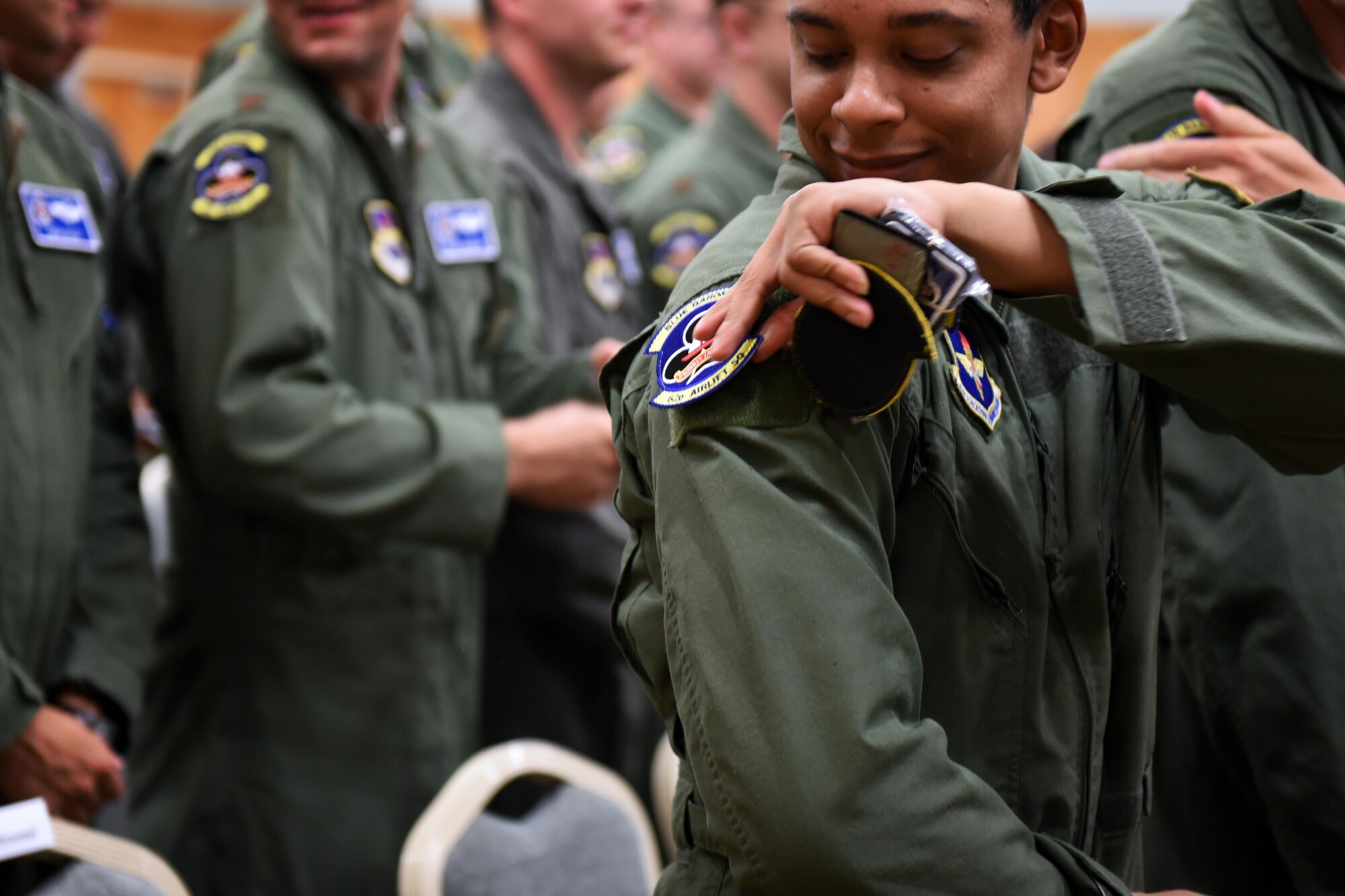 U.S. Air Force Staff Sgt. Terrence Greene, 62nd Airlift Squadron loadmaster instructor, places a new 62nd AS patch on his flight suit during the 48th Airlift Squadron transition ceremony Sept. 30, 2016, at Little Rock Air Force Base, Ark. With the 314th Airlift Wing transitioning away from the C-130H model and being the sole providers of C-130J training, the 48th Airlift Squadron personnel have become members of the 62nd AS.