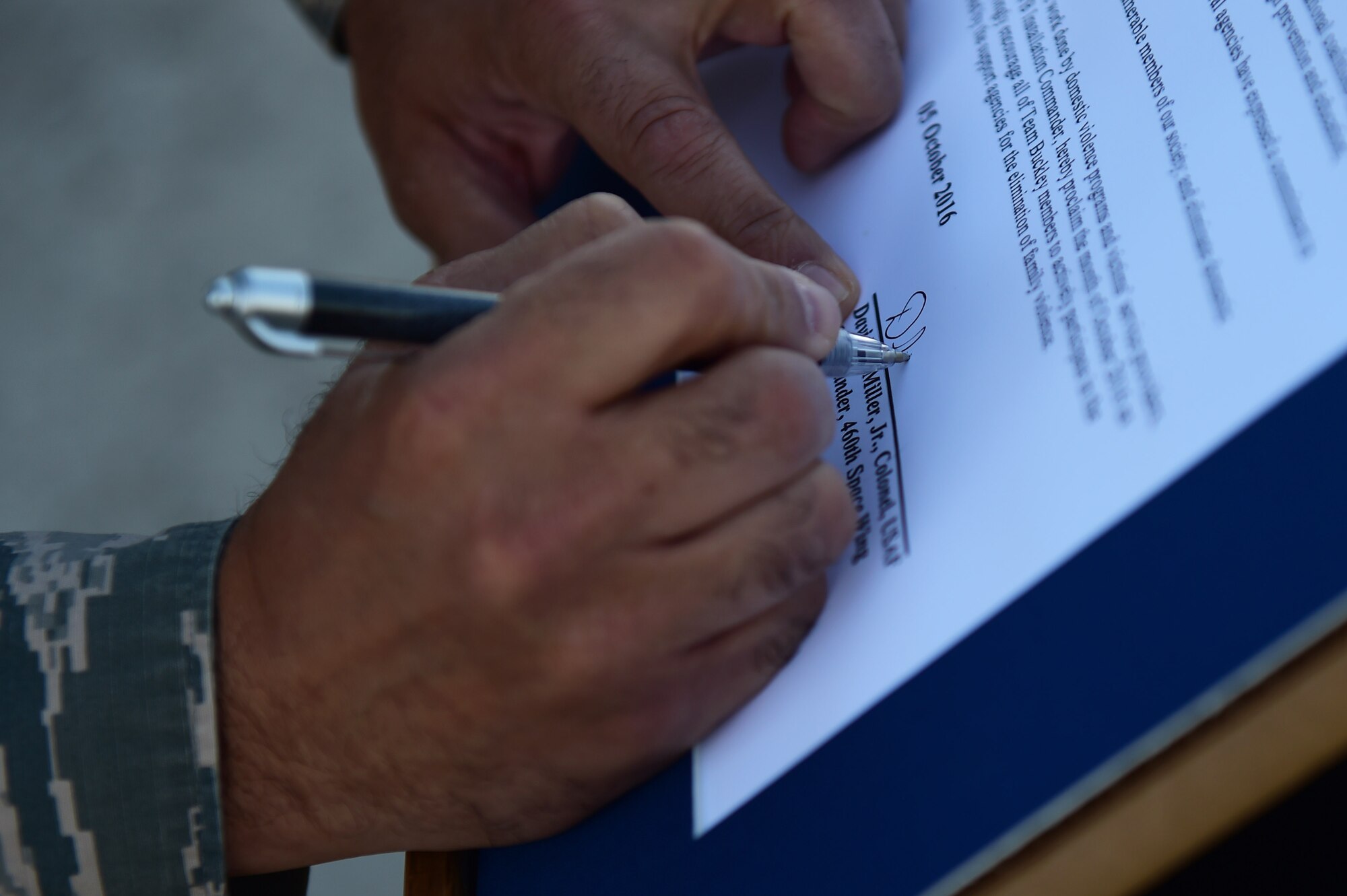 Col. David Miller Jr., 460th Space Wing commander, signs a domestic violence proclamation before a Domestic Violence Awareness Month 5K Run/Walk Oct. 5, 2016, at the outdoor track on Buckley AFB, Colo. The goal of the event was to bring awareness to the issue of domestic violence. (U.S. Air Force photo by Airman 1st Class Gabrielle Spradling/Released)