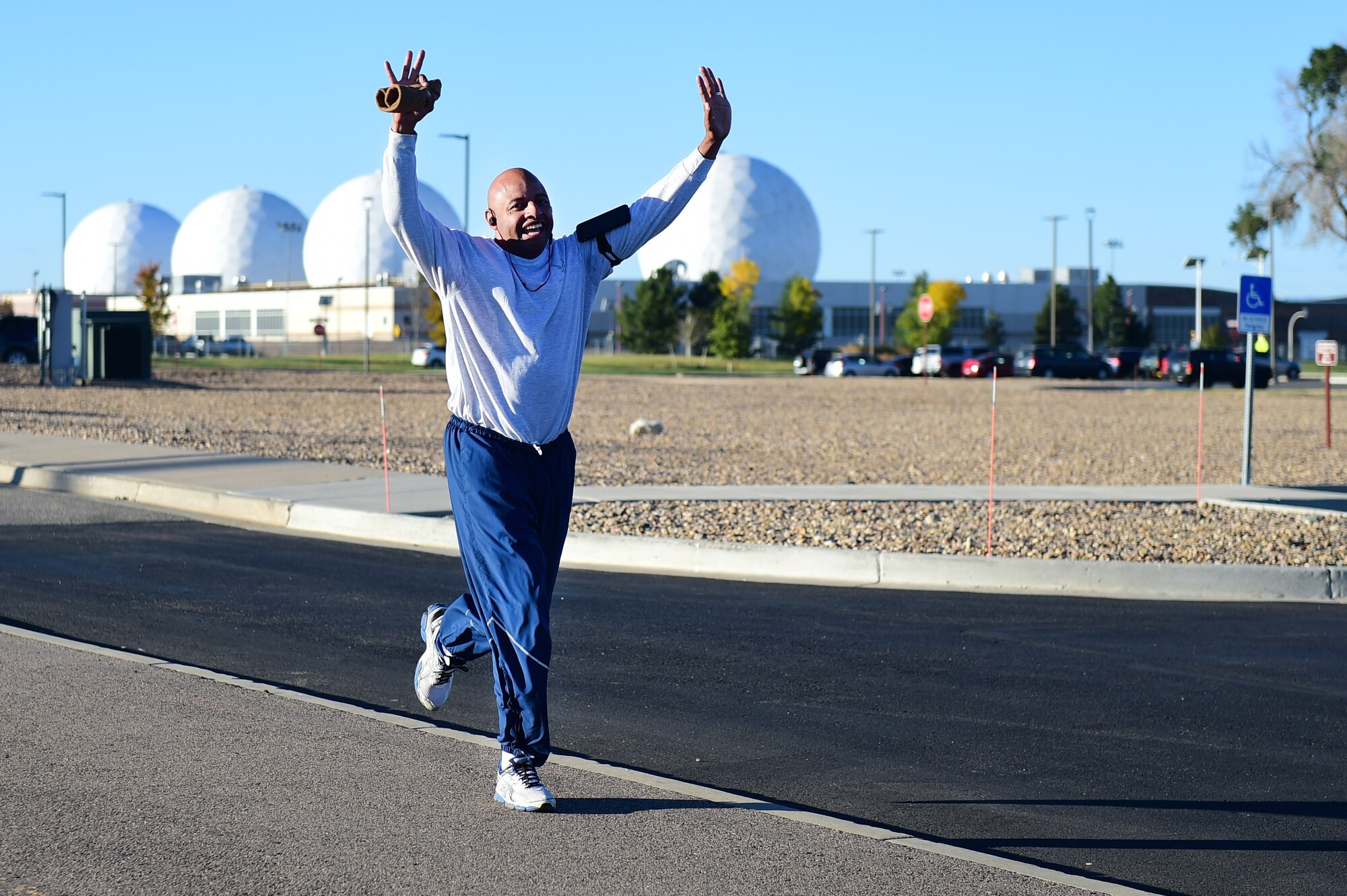 Chief Master Sgt. Rod Lindsey, 460th Space Wing command chief, celebrates as he nears the end of a Domestic Violence Awareness Month 5K Run/Walk Oct. 5, 2016, at the outdoor track on Buckley Air Force Base, Colo. Participants either ran or walked to bring awareness to the one in five women and one in seven men in the United States who, according to National Coalition Against Domestic Violence statistics, have suffered severe physical violence by an intimate partner within their lifetime. (U.S. Air Force photo by Airman 1st Class Gabrielle Spradling/Released)