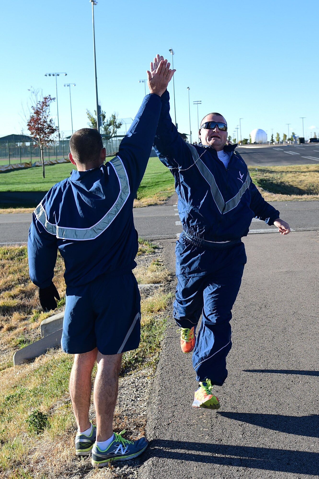 Chief Master Sgt. Mark Fousek, 460th Medical Group superintendent, gives a participant a high five during a Domestic Violence Awareness Month 5K Run/Walk Oct. 5, 2016, at the outdoor track on Buckley Air Force Base, Colo. Participants either ran or walked to bring awareness to those who, according to National Coalition Against Domestic Violence statistics, on an average day, make the more than 20,000 phone calls that are placed to domestic violence hotlines nationwide. (U.S. Air Force photo by Airman 1st Class Gabrielle Spradling/Released)